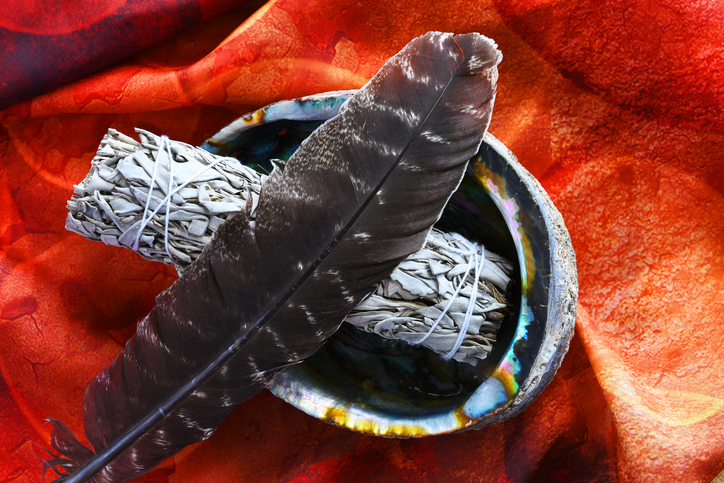 Smudging ceremony elements on orange background.