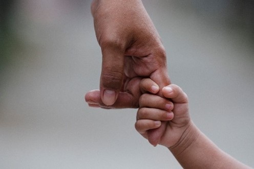 A young child holding an adults hand