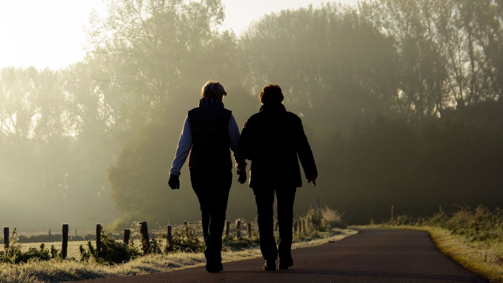 Two women walking on a path in the country.